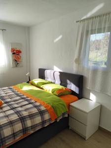 a bedroom with a bed with green and orange sheets at My Flowers in Árgos Orestikón