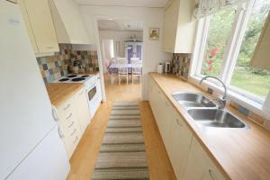 una cucina con lavello e fornello forno superiore di Djupvik - Oland's sunny coast a Borgholm