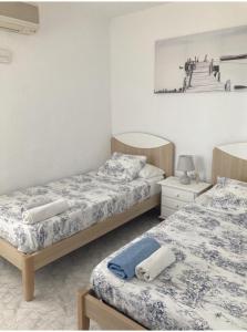 ein Schlafzimmer mit zwei Betten und einem Bild an der Wand in der Unterkunft Cal Gasso Casa Rural con encanto en Delta del Ebro in El Poble Nou del Delta