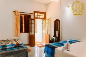 een slaapkamer met twee bedden en een deur naar een kamer bij Green Shade Resort & Haritha Sewana Hotel in Nallathanniya