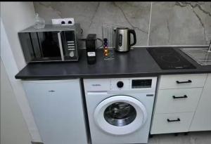 a kitchen counter with a microwave and a washing machine at Studio coquet proche de Lyon in Pont-de-Chéruy