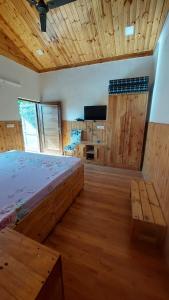 ein großes Schlafzimmer mit einem Bett und einer Holzdecke in der Unterkunft Kutuumb Morni Hills in Morni