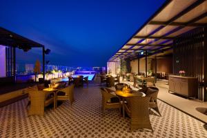 帕坦科特Riviera Sarovar Portico Pathankot的一间带桌椅的餐厅和一个游泳池