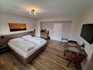 een slaapkamer met een bed, een tafel en een televisie bij Varloh B&B in Varloh