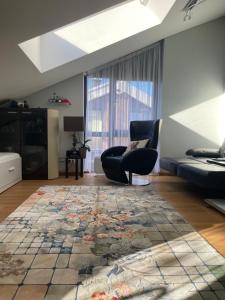 ein Wohnzimmer mit einem Sessel und einem Teppich in der Unterkunft Jūrmaris in Neringa