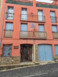 een oranje gebouw met blauwe deuren en ramen bij Appartement Syrah in Collioure