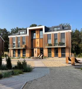 een groot gebouw met een binnenplaats ervoor bij Jurmaris in Neringa +20 foto's