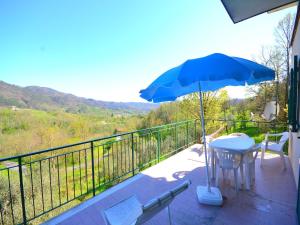 patio con tavolo e ombrellone blu di Spacious home surrounded by nature a Sesta Godano