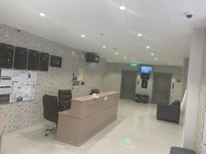 een kantoor met een receptiebalie, stoelen en een tv bij نسيم الربيع 2 للشقق المخدومة in Quai