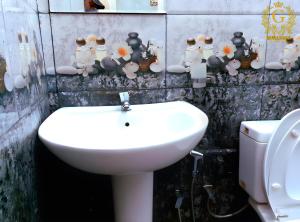 een badkamer met een wastafel, een toilet en enkele beeldjes bij Green Shade Resort & Haritha Sewana Hotel in Nallathanniya