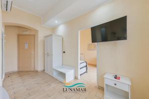 a room with a white cabinet and a tv on a wall at Affittacamere Lunamar in La Spezia +129 photos