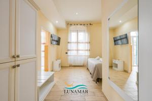 a small room with a bed and a room with a window at Affittacamere Lunamar in La Spezia