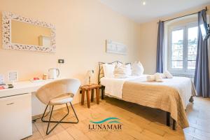 a bedroom with a bed and a desk and a window at Affittacamere Lunamar in La Spezia +107 photos