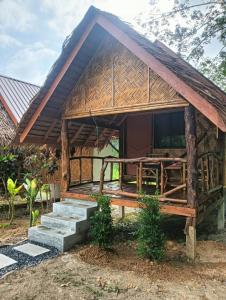 een klein huis met een rieten dak bij Bansuan Lanta Maikaew in Koh Lanta