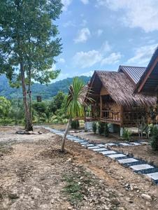 een huis met een palmboom ervoor bij Bansuan Lanta Maikaew in Koh Lanta