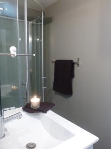 a bathroom with a sink with a candle on it at spéculoos et chicorée in Villeneuve d'Ascq +35 photos