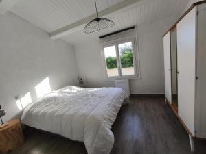 ein Schlafzimmer mit einem weißen Bett und einem Fenster in der Unterkunft Maison 3 chambres avec Jacuzzi à 400m des plages in La Plaine-sur-Mer