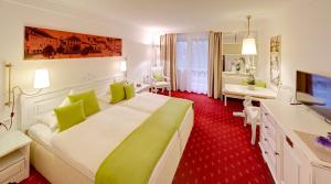 um quarto de hotel com uma cama grande e uma televisão em DAS LUDWIG Sports Resort em Bad Griesbach mais 37 fotografias