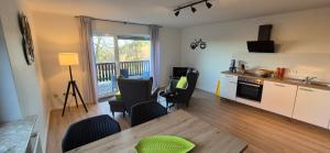 een keuken en woonkamer met een tafel en stoelen bij Haus Im Wald 