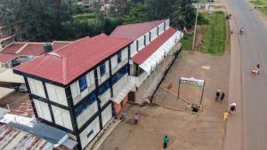 a building with a red roof next to a street at satelite view hotel in Webuye +5 photos