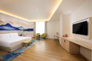 帕坦科特Riviera Sarovar Portico Pathankot的一间配有床和平板电视的酒店房间