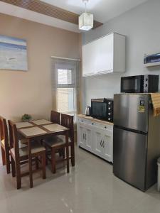 a kitchen with a table and a stainless steel refrigerator at รักตะวัน เวียงพันแสน in Hang Dong
