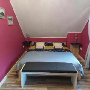 a bedroom with a bed with a red wall at Villa Eva & Lilou Pod Rysianką in Żabnica