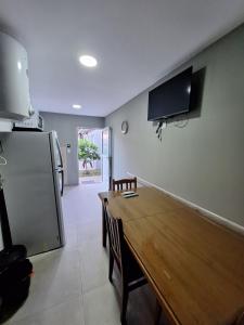 a kitchen with a wooden table and a refrigerator at departamentos 4 personas,N3 Aire acondicionado Wifi TvCable Parrilla in Santa Teresita
