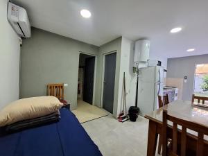 a room with a bed and a table and a kitchen at departamentos 4 personas,N3 Aire acondicionado Wifi TvCable Parrilla in Santa Teresita