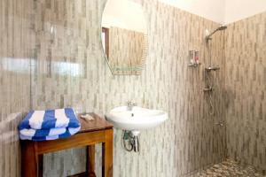 een badkamer met een wastafel en een douche bij Hotel Bonne Nuit in Labuan Bajo