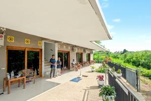 een groep mensen die buiten een gebouw staan bij Hotel Bonne Nuit in Labuan Bajo