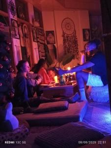 a group of people sitting in a living room with a christmas tree at Buddha house 2 in Kasol