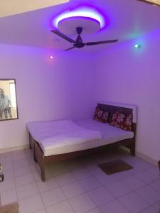 een paarse kamer met een bed met een plafondventilator bij Hotel Maharaja Palace in Lucknow