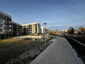 a sidewalk in a city with buildings and a street at Marina Portovo in Gdańsk