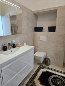 a bathroom with a white sink and a toilet at Apartment Geidorf in Graz +14 photos