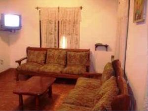 sala de estar con sofá y ventana en El Espinillo en Merlo