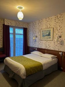een slaapkamer met een groot bed in een kamer bij Hotel le France, Redon in La Celle-sous-Gouzon