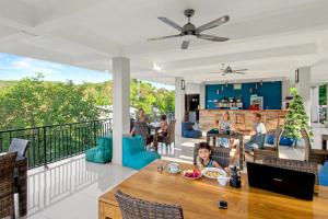 een gezin dat op het balkon van een huis zit bij Hotel Bonne Nuit in Labuan Bajo