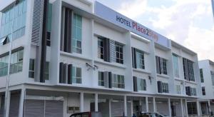 een groot wit gebouw met een bord erop bij Place2stay @ Campus Hub in Kampong Merdang Limau +33 foto's