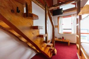 a wooden spiral staircase in a room with a window at Pensiunea Alpin SPA in Ranca
