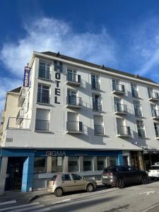 een groot wit gebouw met auto's ervoor geparkeerd bij Hotel le France, Redon in La Celle-sous-Gouzon