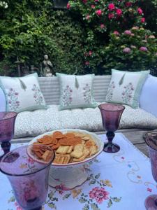 een tafel met een schaal crackers en een bord met snacks bij Centre historique de LYONS LA FORET Hotel de Maître le Cottage in Lyons-la-Forêt