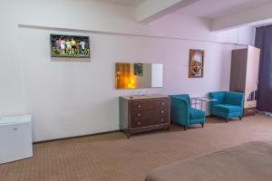 una stanza d'ospedale con due sedie blu e uno specchio di Hotel Parc a Onești