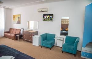 una camera con un letto e due sedie e uno specchio di Hotel Parc a Onești