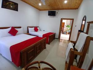 a room with two beds and a television in it at Uthaya Guest House in Mullaittivu