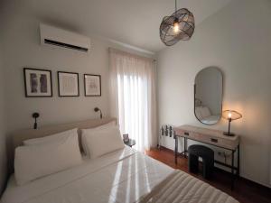 une chambre avec un lit et un bureau avec un miroir dans l'établissement Villa Phos, à Gouves