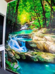 a waterfall in the forest wall mural at Uthaya Guest House in Mullaittivu
