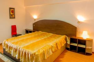 una camera da letto con un letto grande e una sedia rossa di Hotel Parc a Onești Altre 3 foto