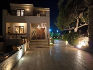 une maison avec un chemin menant à la porte d'entrée la nuit dans l'établissement Villa Phos, à Gouves