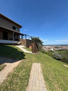 a house with a stone path next to a building at Chalé Alto da Copaiba in Cunha